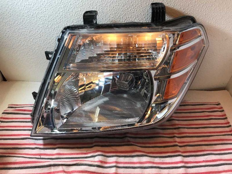Left headlamp assembly composite used genuine OEM Nissan Frontier 2005-2008
