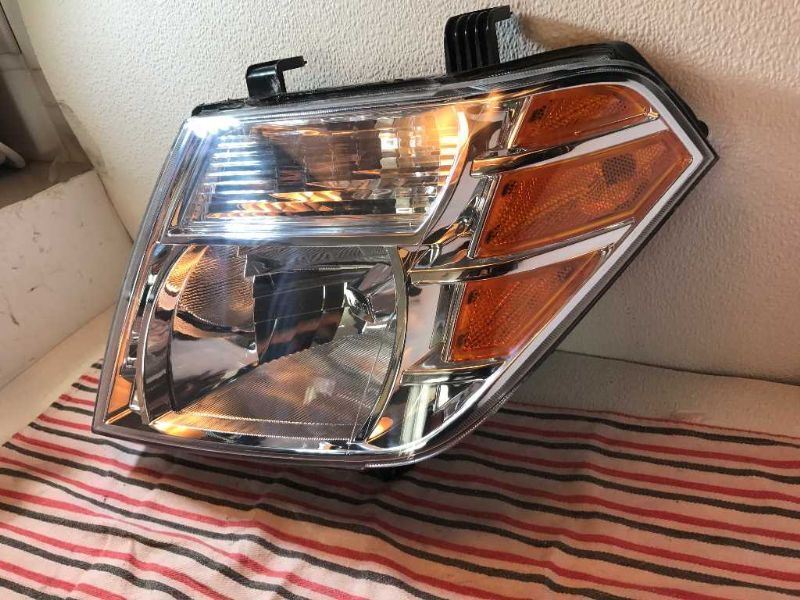 Left headlamp assembly composite used genuine OEM Nissan Frontier 2005-2008