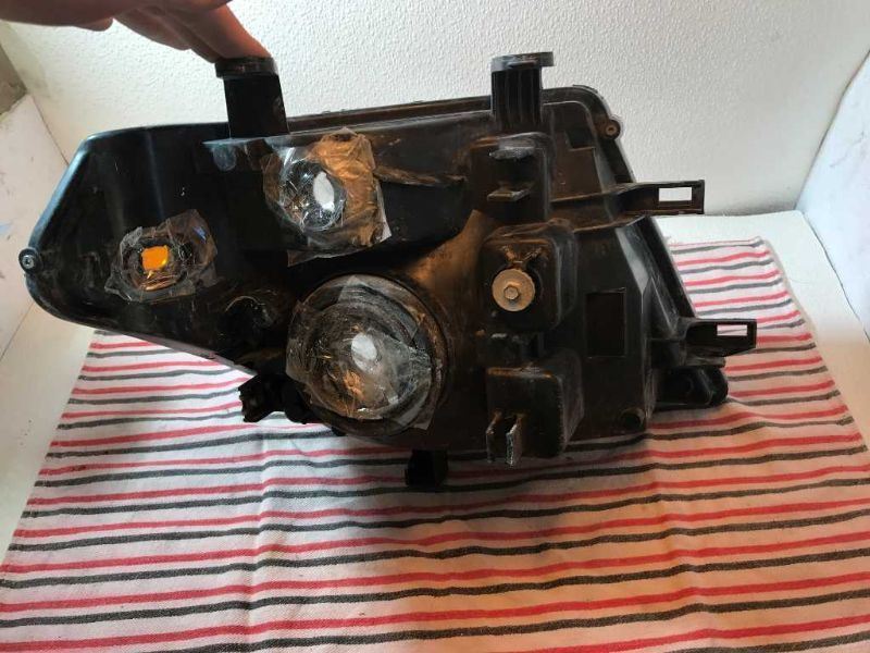 Left headlamp assembly composite used genuine OEM Nissan Frontier 2005-2008